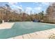 Wide shot of a community pool covered for the off-season surrounded by trees and fencing at 125 Whiterock Dr, Mount Holly, NC 28120
