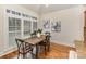 Breakfast nook with wood table next to windows with plantation shutters and hardwood floors at 125 Whiterock Dr, Mount Holly, NC 28120