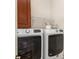 Convenient laundry room with washer, dryer, overhead storage, and countertop space at 125 Whiterock Dr, Mount Holly, NC 28120
