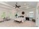 Spacious primary bedroom featuring a tray ceiling, ceiling fan, and abundant natural light at 125 Whiterock Dr, Mount Holly, NC 28120