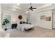 Bright primary bedroom featuring a tray ceiling, ceiling fan, and sitting area at 125 Whiterock Dr, Mount Holly, NC 28120