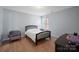 Bedroom featuring neutral wall paint, a chair and light colored hardwood floors at 12820 Settlers Trail Ct, Charlotte, NC 28278