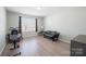 Bonus room featuring an exercise bike, futon, and lots of natural light at 12820 Settlers Trail Ct, Charlotte, NC 28278