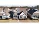 Aerial shot of a tan two-story home featuring a front porch, green shutters, and manicured landscaping at 136 Kingston Dr, Locust, NC 28097