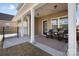 Cozy back porch with rocking chairs, string lights, and a privacy fence at 136 Kingston Dr, Locust, NC 28097