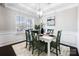 Bright dining room featuring elegant wainscoting, modern light fixture, and a large window at 136 Kingston Dr, Locust, NC 28097