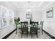 Bright dining room features white wainscoting, a modern chandelier, and table set for six at 136 Kingston Dr, Locust, NC 28097