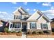 Charming two-story home with a welcoming front porch, manicured landscaping, and a combination of siding and stone accents at 136 Kingston Dr, Locust, NC 28097