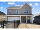 Charming two-story home with a welcoming front porch, two-car garage, and manicured front yard with black fence at 136 Kingston Dr, Locust, NC 28097