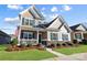 Charming two-story home featuring a covered front porch and manicured lawn under a bright blue sky at 136 Kingston Dr, Locust, NC 28097