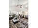 Open-concept living room with high ceilings, large fan, and view of the staircase at 136 Kingston Dr, Locust, NC 28097