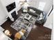 Aerial view of a modern living room with fireplace, dark hardwood floors, and large area rug at 136 Kingston Dr, Locust, NC 28097