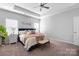 Cozy bedroom featuring a ceiling fan, a ceiling tray, and natural light from two windows at 136 Kingston Dr, Locust, NC 28097