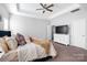Main bedroom with a ceiling fan, a tray ceiling and a TV above a white dresser at 136 Kingston Dr, Locust, NC 28097