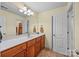 Well-lit bathroom with double vanity, white countertops, and wooden cabinets at 170 Anniston Way, Davidson, NC 28036