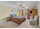 This bedroom features a neutral color scheme, a large bed, a ceiling fan, and a view of the outdoors at 170 Anniston Way, Davidson, NC 28036