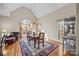 The dining room features a wooden table and chairs, decorative rug, and large windows that allow for ample natural light at 170 Anniston Way, Davidson, NC 28036