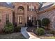 Inviting entrance with landscaped walkway, fountain, and a striking stone and brick facade, for a warm welcome at 170 Anniston Way, Davidson, NC 28036