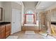 The main bathroom includes a soaking tub, glass-enclosed shower, tiled floors and walls, and a large window at 170 Anniston Way, Davidson, NC 28036