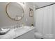 Bathroom with round mirror, updated fixtures, and white marble vanity at 2010 Hollyhedge Ln, Indian Trail, NC 28079