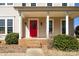 Inviting front porch showcases a bold red door, classic white columns, and manicured landscaping at 2010 Hollyhedge Ln, Indian Trail, NC 28079