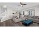 Open living room with a comfortable sectional sofa, modern ottoman, and staircase at 2010 Hollyhedge Ln, Indian Trail, NC 28079