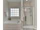 Bathroom featuring a bathtub, shower with glass doors, and frosted glass window for privacy at 2017 Bridleside Dr, Indian Trail, NC 28079