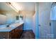 Well-lit bathroom featuring a double sink vanity, large mirror and tile flooring at 2017 Bridleside Dr, Indian Trail, NC 28079