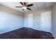 Cozy bedroom with dark hardwood floors, a ceiling fan and two white doors at 2017 Bridleside Dr, Indian Trail, NC 28079