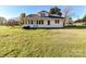 Rear exterior showcasing a well-kept lawn and ample backyard space, under a clear blue sky at 214 W Elm St, Wingate, NC 28174