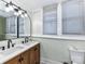 Bathroom features a wood cabinet vanity with double sinks, updated faucet fixtures and a toilet at 214 W Elm St, Wingate, NC 28174