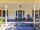 Inviting covered front porch features rocking chairs, side tables, and colorful potted plants at 214 W Elm St, Wingate, NC 28174