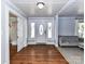 Bright living room featuring hardwood floors, front entry access, and a comfortable gray couch at 214 W Elm St, Wingate, NC 28174