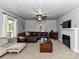 Inviting living room features a cozy fireplace, neutral carpet and a comfortable leather sectional sofa at 214 W Elm St, Wingate, NC 28174