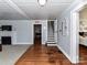 Open-concept living room featuring hardwood floors, a fireplace, and access to the staircase at 214 W Elm St, Wingate, NC 28174