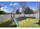 This backyard features a white fence, a swing set with a blue slide, and green grass at 224 Mills Ln, Fort Mill, SC 29708