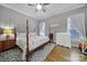 Traditional bedroom with a wooden four-poster bed, a dresser, and two windows with natural light at 224 Mills Ln, Fort Mill, SC 29708