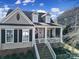 Inviting home showcasing a covered front porch with columns and a classic American flag at 224 Mills Ln, Fort Mill, SC 29708