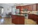 Well-lit kitchen boasts cherry cabinets, granite countertops, stainless steel appliances, and a center island at 224 Mills Ln, Fort Mill, SC 29708