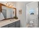 Bright bathroom features a wooden-framed mirror, gray vanity, and shower at 2283 Iron Works Dr, Clover, SC 29710