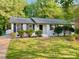 Charming single-story home featuring a brick facade, manicured lawn, and mature trees at 2314 Knickerbocker Dr, Charlotte, NC 28212