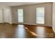 Sun-drenched living room with large windows, hardwood floors, and fresh paint at 2314 Knickerbocker Dr, Charlotte, NC 28212