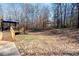 A wooden deck overlooks the sloped backyard with mature trees and natural surroundings at 237 Creekstone Ln, York, SC 29745