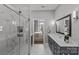Modern bathroom showcasing a walk-in shower, double vanity sinks, and views of the bedroom at 2401 Euclid Ave # 213, Charlotte, NC 28203