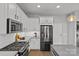 An island kitchen features stainless appliances and bright white cabinetry, and modern design at 2401 Euclid Ave # 213, Charlotte, NC 28203