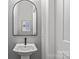 Stylish powder room featuring a pedestal sink, arched mirror and modern fixtures to accommodate guests at 2401 Euclid Ave # 213, Charlotte, NC 28203