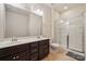Bathroom featuring double sinks, dark wood cabinetry, tile flooring, and a glass-enclosed shower at 241 Catoctin Rd, Rock Hill, SC 29732