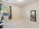 A simple, carpeted bedroom with a window, a large mirror, and neutral wall colors, offering a blank canvas at 241 Catoctin Rd, Rock Hill, SC 29732