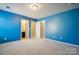 Spacious bedroom with bright blue walls, neutral carpet, and open doorways at 241 Catoctin Rd, Rock Hill, SC 29732