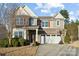 Two-story home featuring brick accents, a two-car garage, well-maintained landscaping, and a basketball hoop on the driveway at 241 Catoctin Rd, Rock Hill, SC 29732